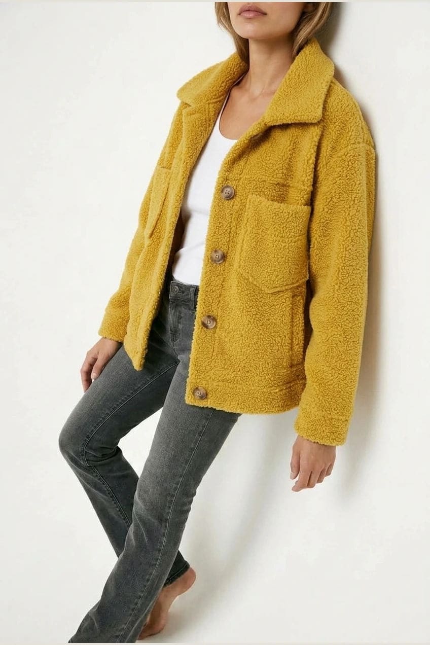 Woman wearing an open teddy-textured button-front jacket with a collar, chest pockets and lower pockets, with jeans and ankle boots._8