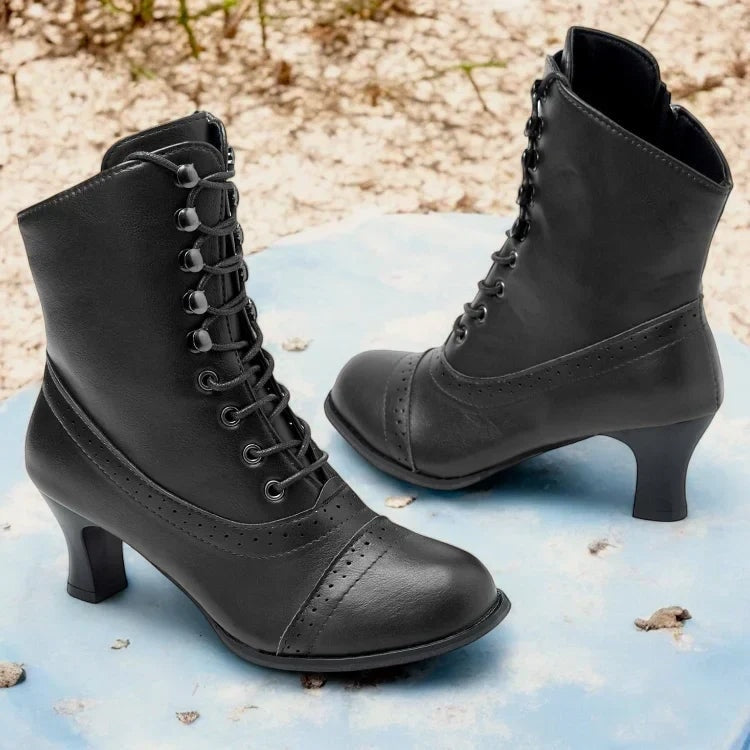 Pair of black lace-up mid-heel boots showing the tall shafts, curved heels, decorative perforations, and rounded toes.