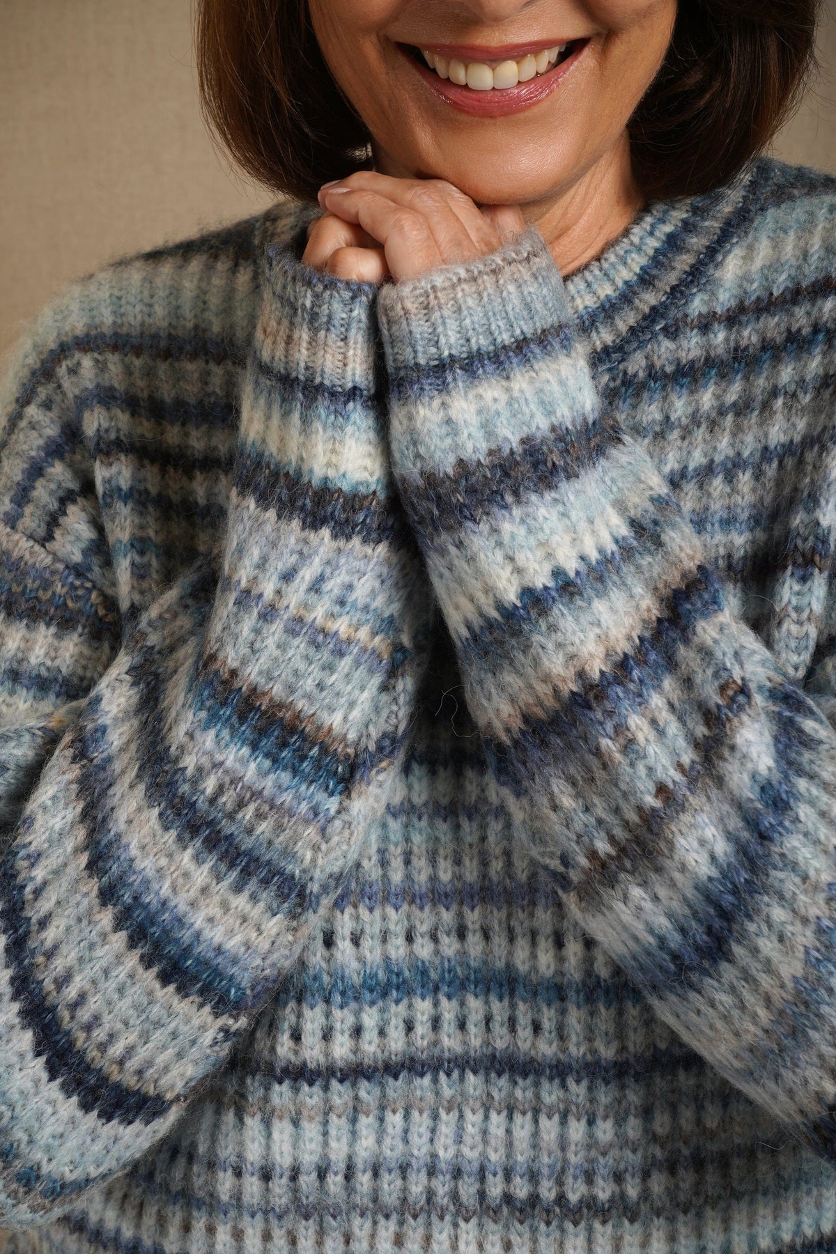 Woman sitting on a sofa wearing a striped ribbed knit crew neck jumper with long sleeves and jeans._5