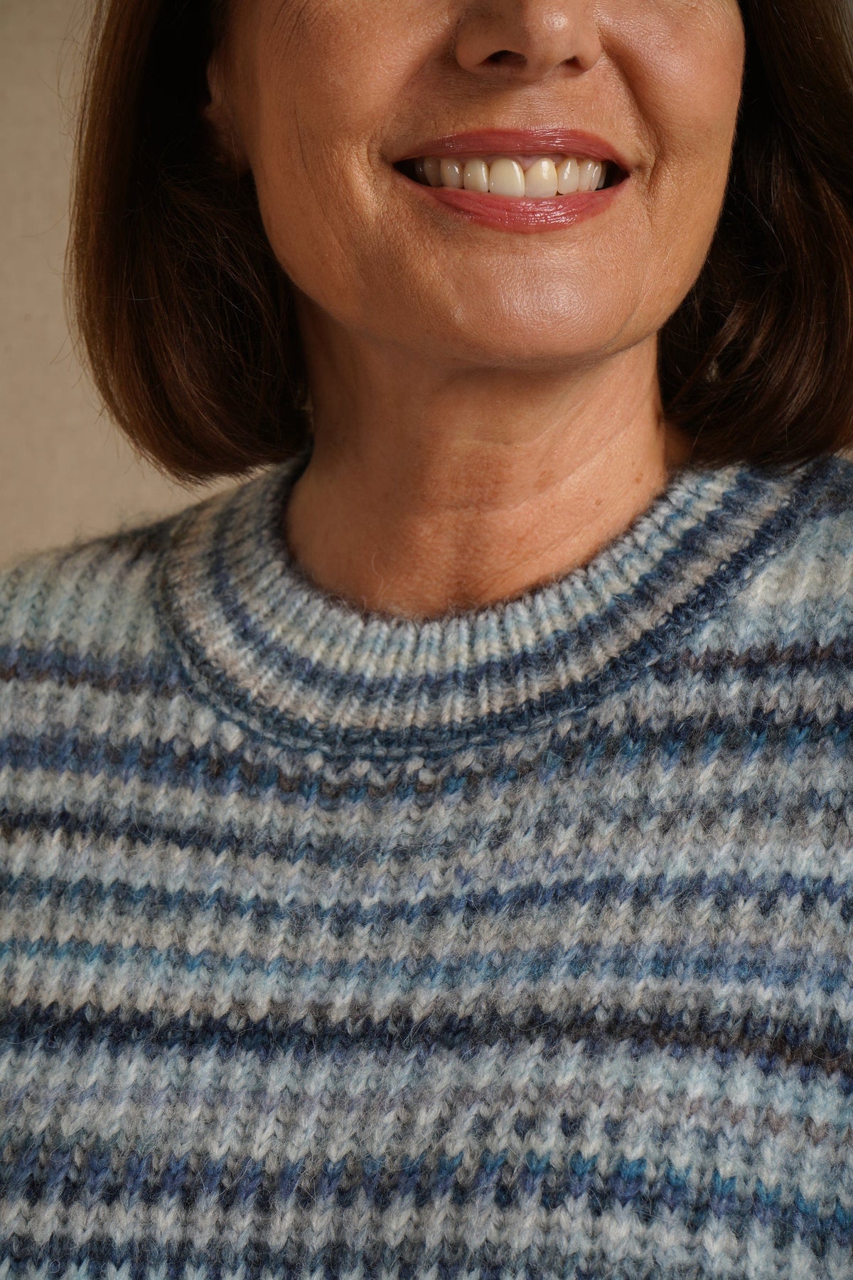 Woman sitting on a sofa wearing a striped ribbed knit crew neck jumper with long sleeves and jeans._6