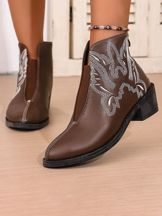 Brown ankle boots with white Western embroidery and elastic side panels, styled on a model wearing an anklet._0