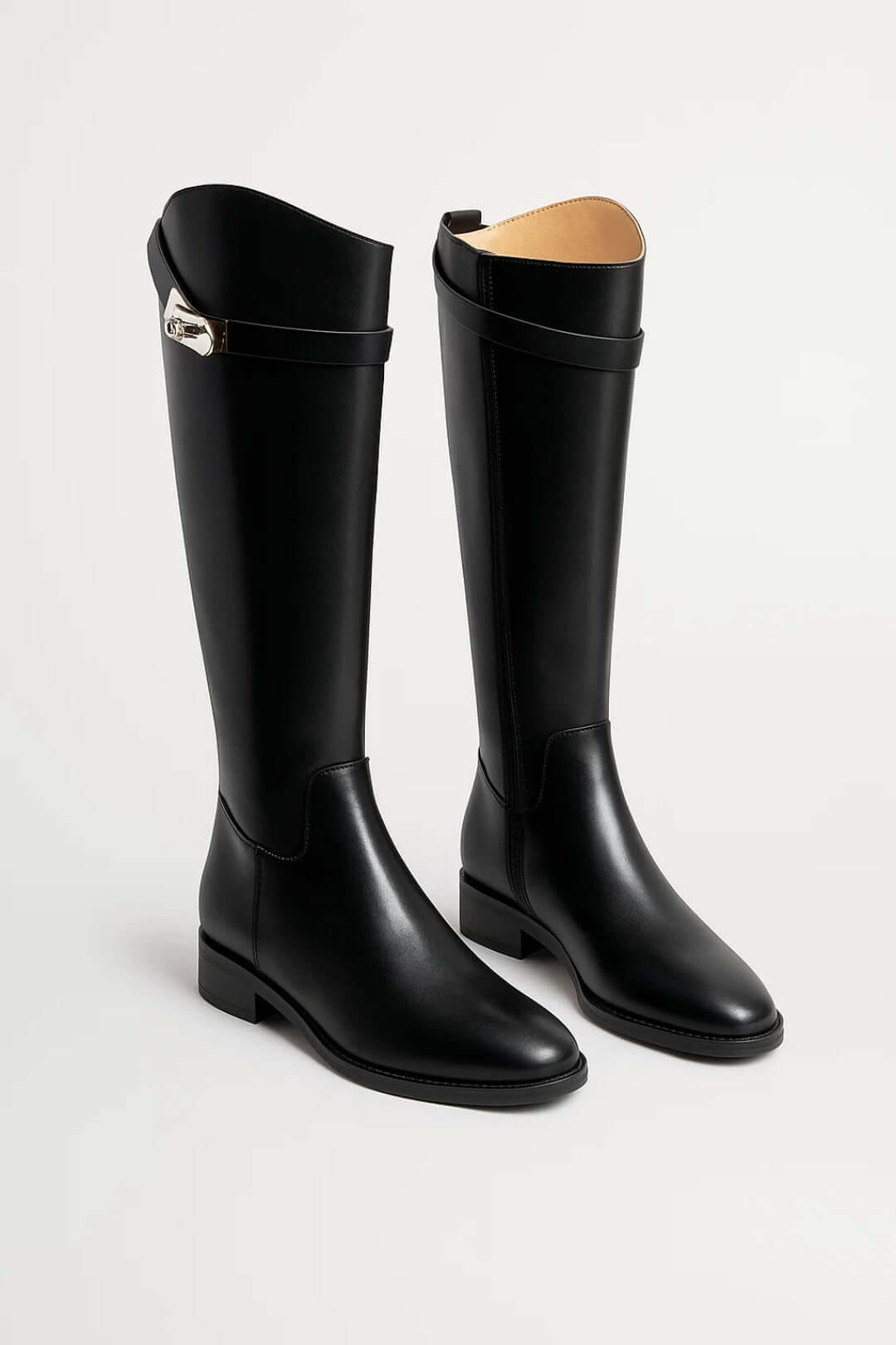 Black knee-high riding boots with low heels, smooth uppers, rounded toes, and buckle straps near the openings.