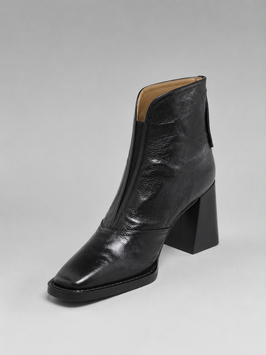 Black ankle boot with an angular toe, glossy finish, front zip, and tall block heel shown from the front three-quarter view.