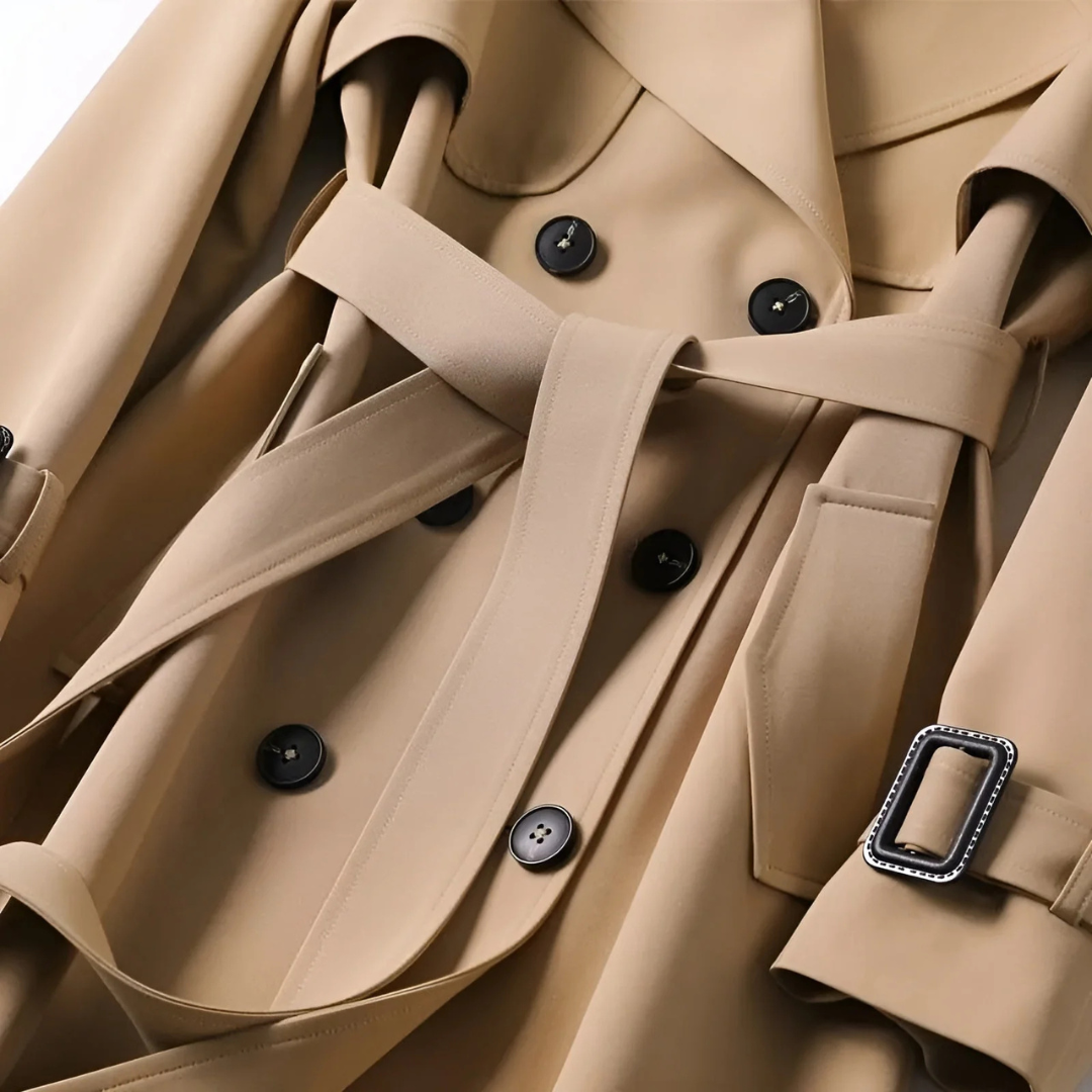 A woman wears a belted double breasted trench coat with notched lapels on a city street._4