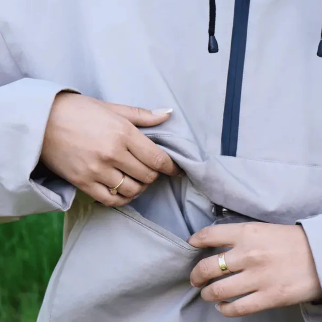 A model wears a hooded half zip anorak jacket with a large front pocket in a mountain setting._14