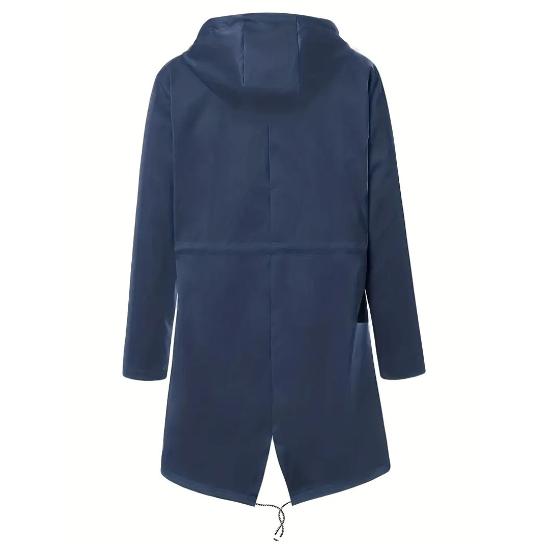 Model wearing a hooded long rain coat with a front zip, drawstring waist, and front pockets on a wet city street._15