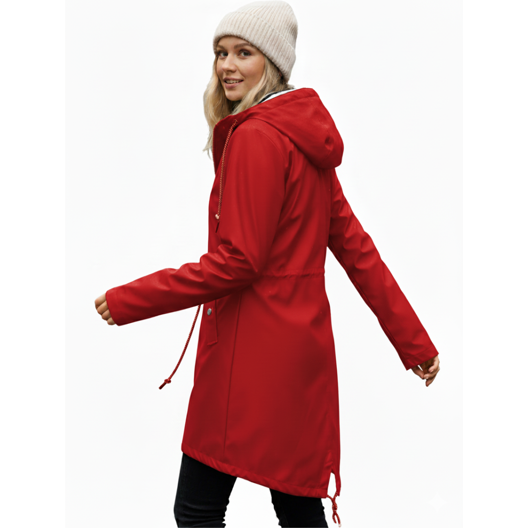 Model wearing a hooded long rain coat with a front zip, drawstring waist, and front pockets on a wet city street._18