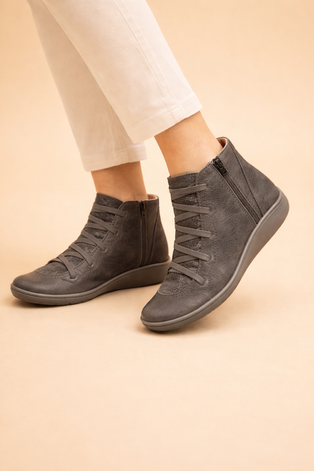 Dark gray women's lace-up ankle boots shown from the side, highlighting the visible outer ankle zips and contrasting soles.